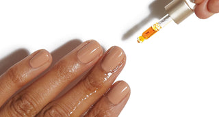 woman with manicured nails applying cuticle oil