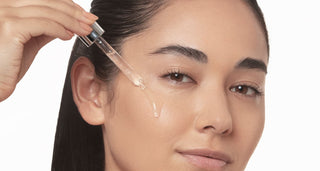Woman is applying serum to her face for radiant skin