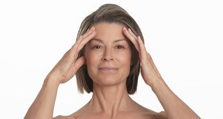 Woman gently touching her temples, illustrating healthy-looking skin and skin barrier care